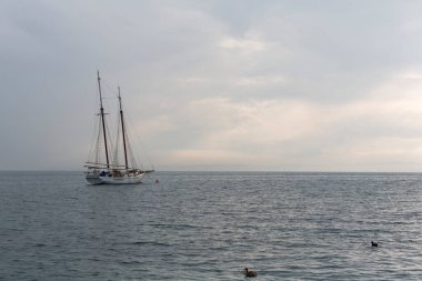 Garda Gölü 'nde, Sirmione açıklarında gün batımında dalgaların olduğu kadim bir tekne. Garda Gölü 'nde Sirmione açıklarında yüksek kaliteli bir tekne Sunsethoto' da dalgaların altında sallanıyor.
