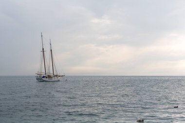 Garda Gölü 'nde, Sirmione açıklarında gün batımında dalgaların olduğu kadim bir tekne. Garda Gölü 'nde Sirmione açıklarında yüksek kaliteli bir tekne Sunsethoto' da dalgaların altında sallanıyor.