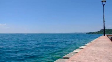 Güzel bir yaz gününde Garda Sirmione Gölü sütunları ve iskelesi gölde.