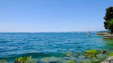 Güzel bir yaz gününde Garda Sirmione Gölü sütunları ve iskelesi gölde.