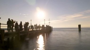 Garda Gölü 'ndeki sirmione rıhtımında gün batımında insanlarla güzel bir zaman atlaması.