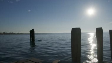 Sirmione rıhtımında, Garda Gölü 'nde gün batımında insanlarla.