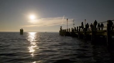 Garda Gölü 'ndeki sirmione rıhtımında gün batımında insanlarla güzel bir zaman atlaması.