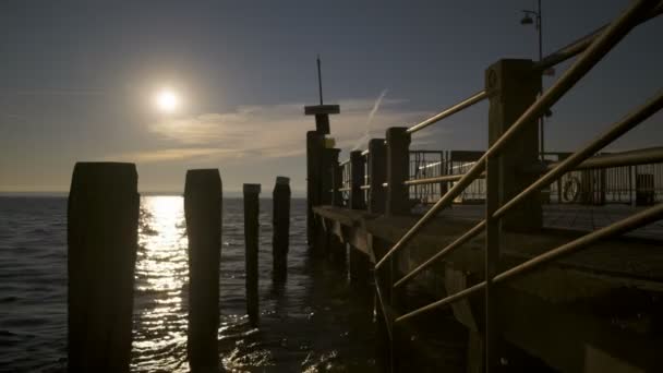 日落时与人在加尔达湖上美丽的时光飞逝码头 — 图库视频影像