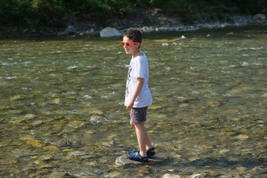 Reggio Emilia İtalya 'daki Enza nehrinin kıyısında güzel bir çocuk oynuyor. Yüksek kalite fotoğraf