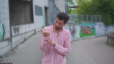 Güzel çocuk modeli çizgili gömleğin kolunu bağlar.
