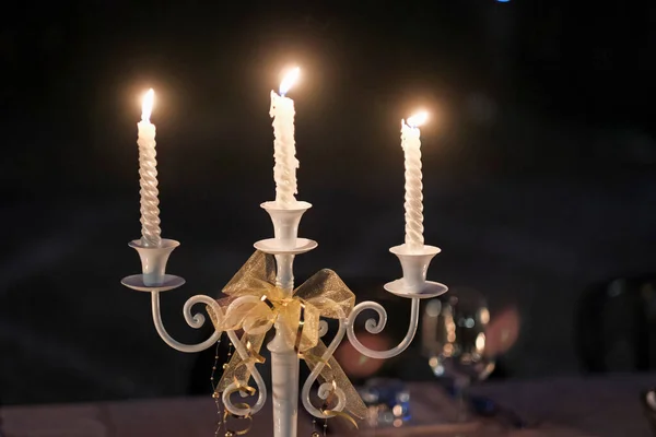 3分枝烛台 白色的蜡烛点亮在铺好的桌子上和黑色的背景 高质量的照片 — 图库照片