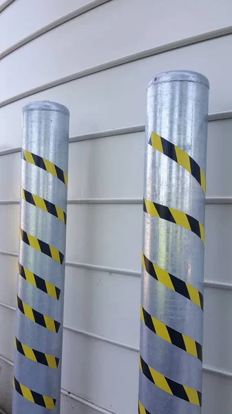 aluminum columns with yellow and black warning signs near feed silos. High quality photo