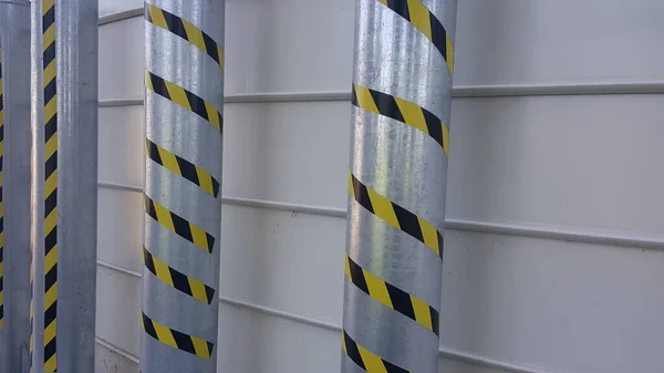 aluminum columns with yellow and black warning signs near feed silos. High quality photo