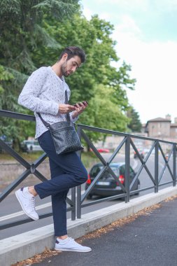 Güzel siyah saçlı İtalyan adam şehirdeki telefona cevap veriyor. Yüksek kalite fotoğraf
