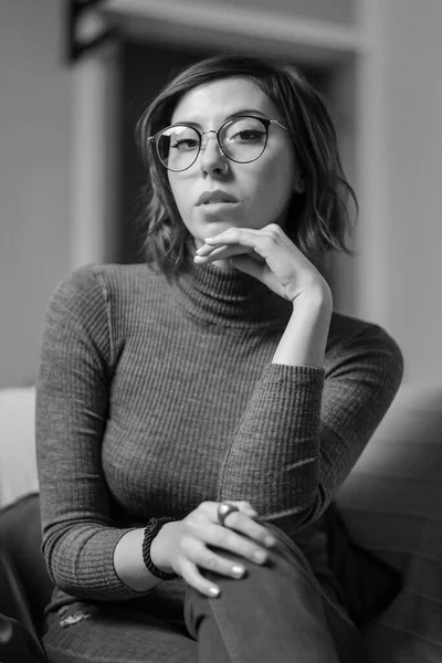 美しい女の子は ソファの上で顔のメガネのセーターやジーンズをクローズアップ描いた 高品質の写真 — ストック写真