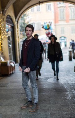 Şehir merkezinde ceketi ve koyu renk gömleği olan güzel bir adam poz veriyor. Yüksek kalite fotoğraf