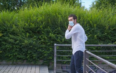 Şehirde dolaşan beyaz bir çocuk virüs önleyici cerrahi maske takıyor. Yüksek kalite fotoğraf