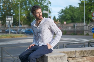 Beyaz çocuk şehir merkezinde bir tırabzanda oturuyor. Yüksek kalite fotoğraf