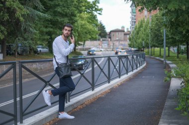 Beyaz çocuk şehir merkezinde bir tırabzanda oturuyor. Yüksek kalite fotoğraf