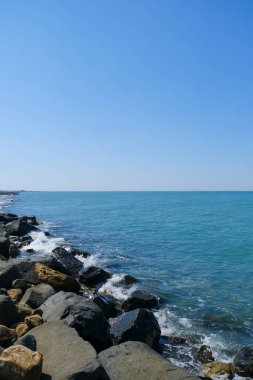 Deniz dalgaları ve mavi gökyüzü Ostia Roma 'sı olan kayalar. Yüksek kalite fotoğraf