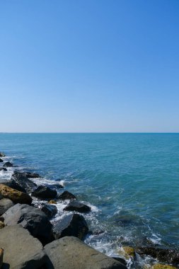 Deniz dalgaları ve mavi gökyüzü Ostia Roma 'sı olan kayalar. Yüksek kalite fotoğraf