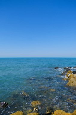 Deniz dalgaları ve mavi gökyüzü Ostia Roma 'sı olan kayalar. Yüksek kalite fotoğraf
