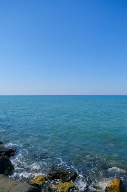 Deniz dalgaları ve mavi gökyüzü Ostia Roma 'sı olan kayalar. Yüksek kalite fotoğraf