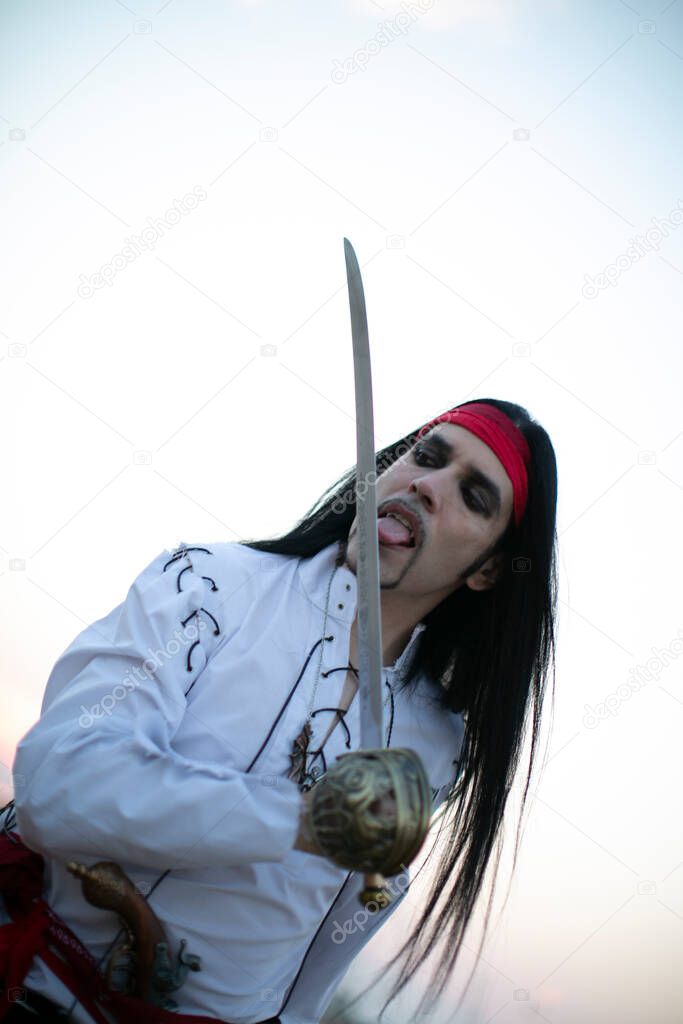 beautiful model with vampire pirate costume at the beach and long black hair
