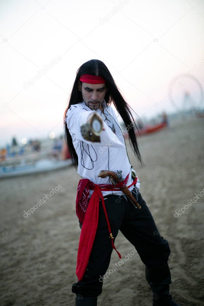 beautiful model with vampire pirate costume at the beach and long black hair