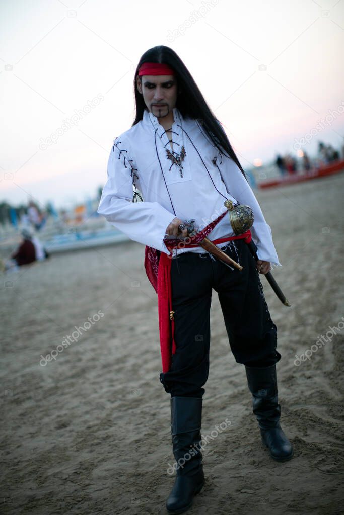 beautiful model with vampire pirate costume at the beach and long black hair