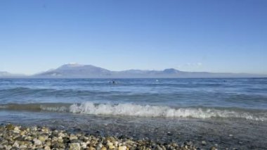 Güneşli bir günde Garda Sirmione Gölü kayalıklarda dalgalanır. Yüksek kalite 4k görüntü