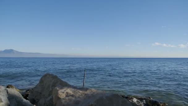 阳光明媚的日子里 加尔达湖在岩石上摇曳 高质量的4K镜头 — 图库视频影像