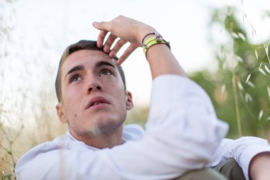 Dışarıda tişörtle poz veren yakışıklı bir adam.