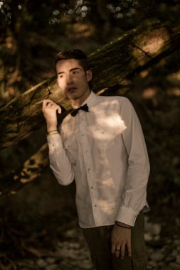 Dışarıda tişörtle poz veren yakışıklı bir adam.