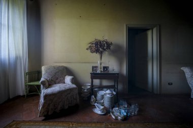 Terk edilmiş evde kanepe ve lamba olan bir oda. 