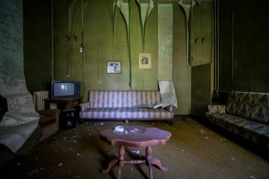 Terk edilmiş evde kanepe ve lamba olan bir oda. 