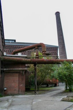 Duisburg, Almanya 'da eski bir endüstriyel fabrikanın eski, yıpranmış tuğla binası ve paslı makineleri, şimdi sanayi mirası için bir kamu parkı. Yüksek kalite fotoğraf