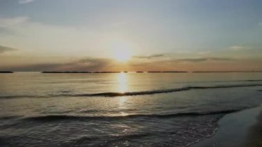 Güneş batarken sakin Adriyatik Denizi 'nde kürek çeken bir insanın huzurlu ve manzaralı görüntüsü suya güzel bir altın yansıma yansıtıyor. Riviera Romagnola Cesenatico Rini 'de. Yüksek kalite