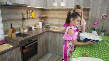 Mom teaching her daughter how to bake a pie