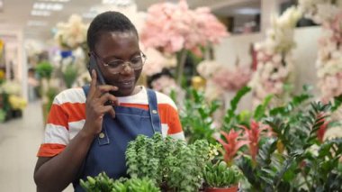 African american florist talking on phone in flower shop