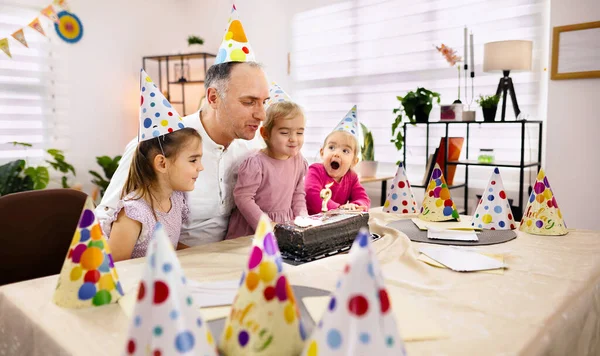 Aile üyeleri bir masanın etrafında toplanıp pasta ve heyecan paylaşıyorlar..