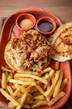 Crispy fried chicken sandwich on a soft bun, served with golden fries and tasty dipping sauces deliciously inviting