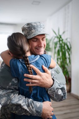 Soldier father hugging his daughter after returning home from military service
