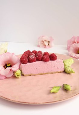 Ahudududulu cheesecake, taze çiçekli fotoğraf, pembe kek, beyaz arka plan konsept yiyecek sanatı tabağında böğürtlenli pasta.