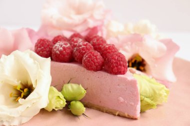 Ahudududulu cheesecake, taze çiçekli fotoğraf, pembe kek, beyaz arka plan konsept yiyecek sanatı tabağında böğürtlenli pasta.