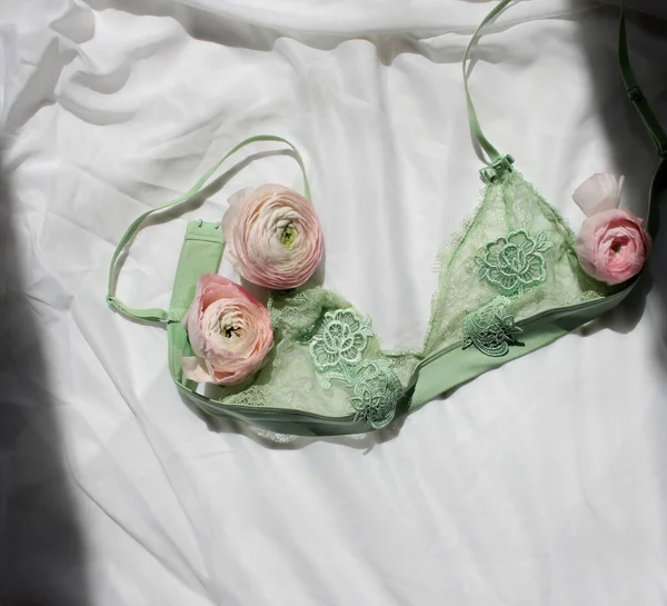 Pembe ranunculus çiçek tomurcukları düz yatay fotoğraf, beyaz arka planda yeşil dantel sütyen, taze çiçekler, yumuşak ev dekorasyonu.