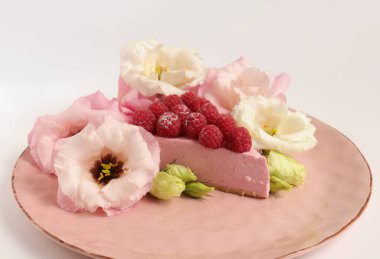 Ahudududulu cheesecake, taze çiçekli fotoğraf, pembe kek, beyaz arka plan konsept yiyecek sanatı tabağında böğürtlenli pasta.