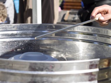 Genç bir adam pamuk şeker üzerinden yapar. Cihazı yakın kendi üretimi için ..