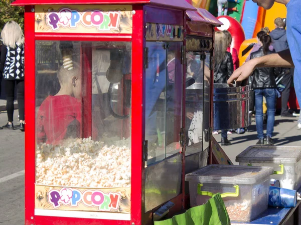 Patlamış mısır ve pamuk şeker Meydanı'nda bir genç adam satıyor.