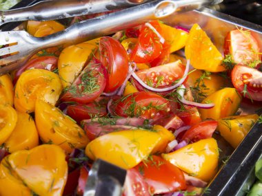 Domates kırmızı ve sarı, büyük dilimler halinde kesilir. Bitkisel yağ, kırmızı soğan ve kokulu yeşillikleri salatası.