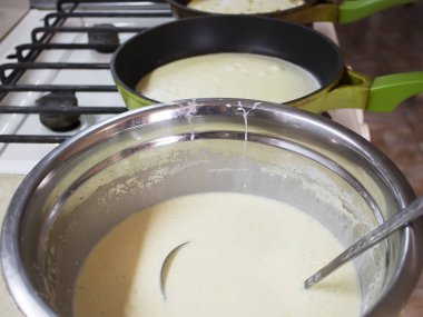 Cooking pancakes in the home kitchen. Pan with dough.