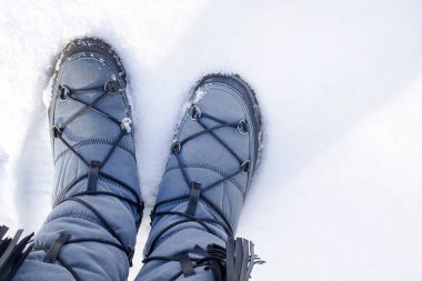 Süslü çizmeleri ayaklarda beyaz kabarık kar üzerinde durmak. Varış veya çıkış kış kavramı.