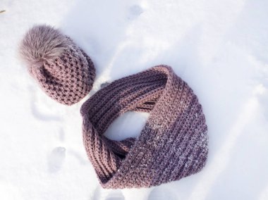 Kış şapka bir eşarp ile beyaz kar üzerinde vardır. Varış veya çıkış kış kavramı.