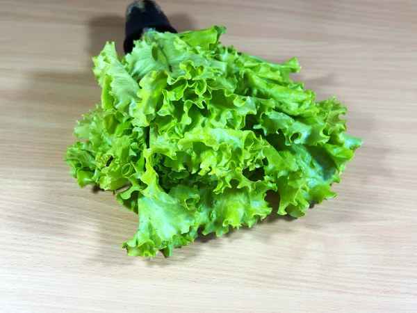 Green leafy vegetables. Salad is located on the cutting table.